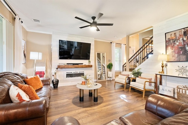 14908 Chamomile Cv, Pflugerville, TX 78660 - living room featuring stairs, wood finished floors, ceiling fan, and crown molding