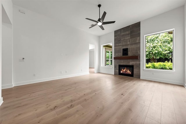 3937 Veneto Cir, Leander, TX 78641 - unfurnished living room with light wood-style floors, a tile fireplace, and a ceiling fan