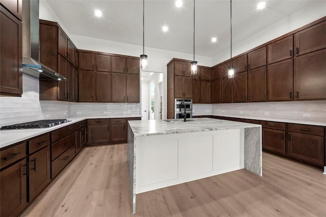 3937 Veneto Cir, Leander, TX 78641 - kitchen featuring wall chimney range hood, stainless steel appliances, tasteful backsplash, an island with sink, and recessed lighting