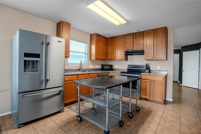 8925 China Rose Dr, Austin, TX 78724 - kitchen with high quality fridge, range with electric cooktop, under cabinet range hood, black microwave, and light tile patterned floors