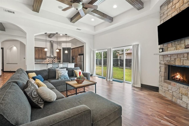 1310 Minnie Dr, Austin, TX 78732 - living room with coffered ceiling, a ceiling fan, beamed ceiling, a stone fireplace, and hardwood / wood-style floors