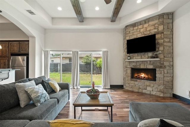 1310 Minnie Dr, Austin, TX 78732 - living area featuring beamed ceiling, a fireplace, arched walkways, a ceiling fan, and wood finished floors