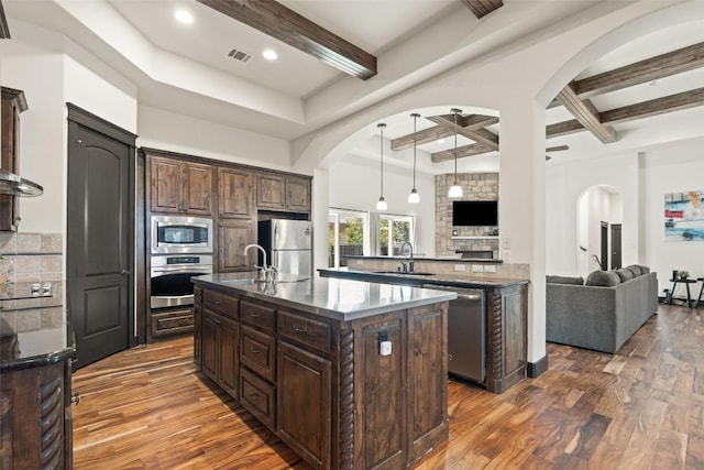 1310 Minnie Dr, Austin, TX 78732 - kitchen featuring arched walkways, stainless steel appliances, dark wood-type flooring, dark brown cabinets, and beam ceiling