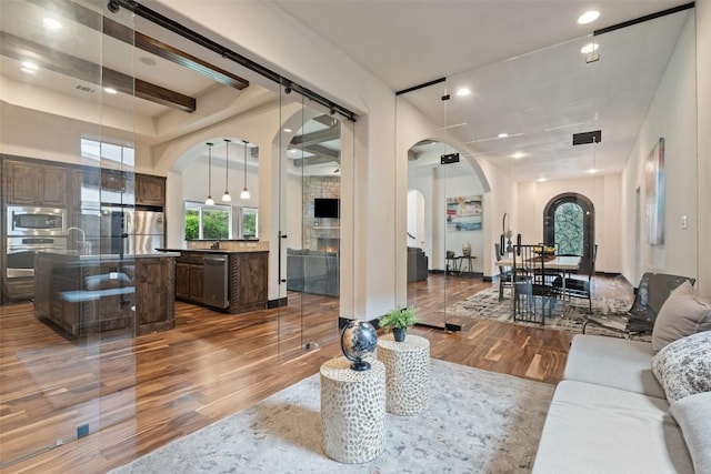 1310 Minnie Dr, Austin, TX 78732 - living room featuring arched walkways, wood finished floors, and recessed lighting