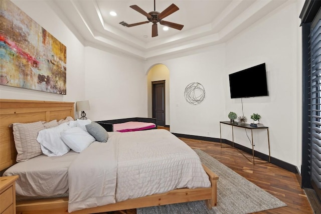 1310 Minnie Dr, Austin, TX 78732 - bedroom featuring arched walkways, a tray ceiling, wood finished floors, recessed lighting, and a ceiling fan