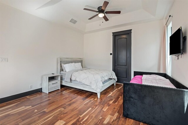 1310 Minnie Dr, Austin, TX 78732 - bedroom featuring a tray ceiling, wood finished floors, and a ceiling fan