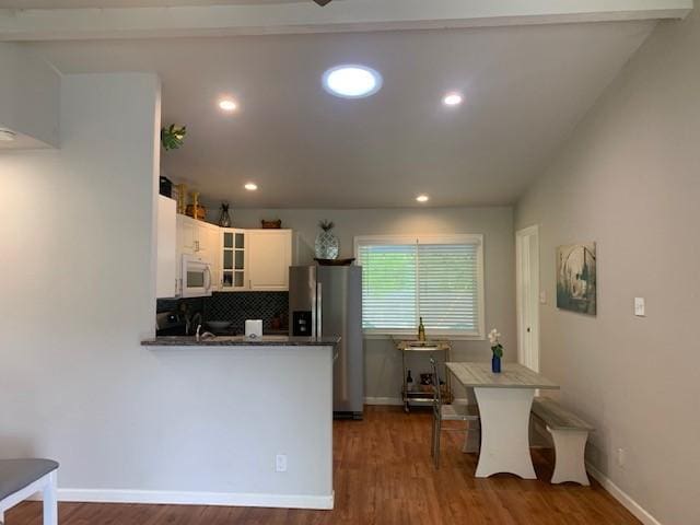 6004 Blythewood Dr, Austin, TX 78745 - kitchen with white microwave, stainless steel fridge, dark wood-type flooring, a peninsula, and recessed lighting