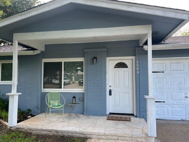 6004 Blythewood Dr, Austin, TX 78745 - view of exterior entry with brick siding, covered porch, and a garage