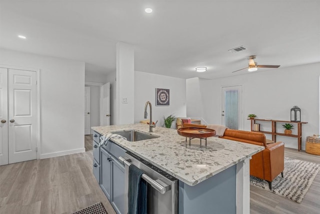 837 Mica Ln, Leander, TX 78641 - kitchen featuring stainless steel dishwasher, light wood-style flooring, open floor plan, light stone counters, and ceiling fan