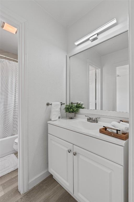 837 Mica Ln, Leander, TX 78641 - bathroom with vanity, wood finished floors, and shower / bath combo with shower curtain