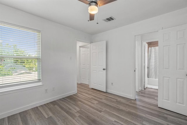 837 Mica Ln, Leander, TX 78641 - unfurnished bedroom featuring wood finished floors, multiple windows, and ceiling fan