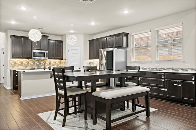2433 Roaring River Trl, Leander, TX 78641 - kitchen featuring stainless steel appliances, tasteful backsplash, dark wood-style flooring, light countertops, and recessed lighting