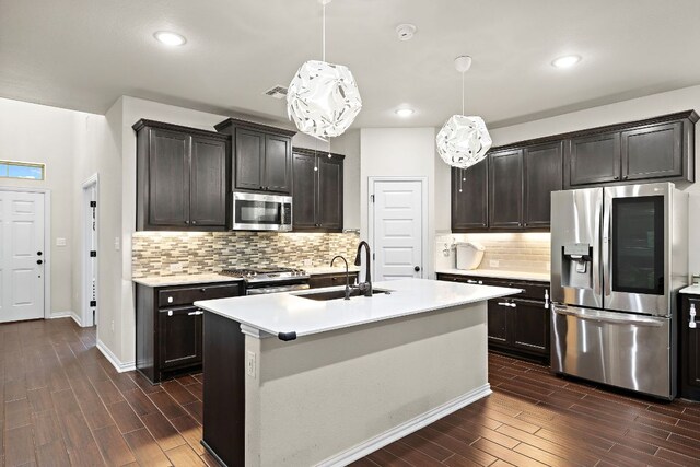 2433 Roaring River Trl, Leander, TX 78641 - kitchen featuring appliances with stainless steel finishes, dark wood finished floors, light countertops, recessed lighting, and decorative backsplash