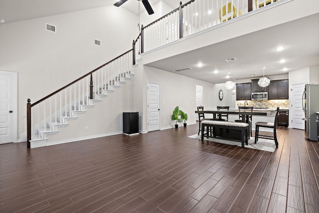 2433 Roaring River Trl, Leander, TX 78641 - living area featuring a towering ceiling, dark wood-style floors, stairway, a ceiling fan, and recessed lighting