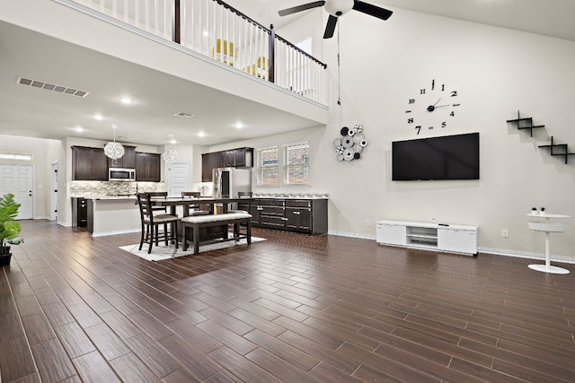 2433 Roaring River Trl, Leander, TX 78641 - living room featuring ceiling fan, plenty of natural light, dark wood-style flooring, recessed lighting, and a towering ceiling