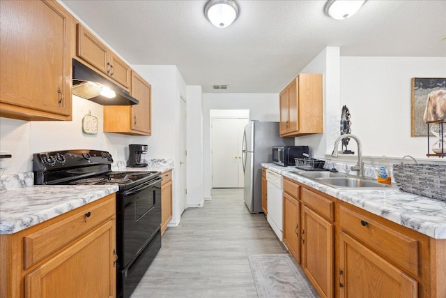 8710 Davis Oaks Trl, Austin, TX 78748 - kitchen with black range with electric stovetop, under cabinet range hood, stainless steel microwave, dishwasher, and light wood-style floors