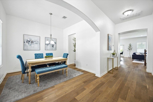 2216 Lookout Knoll Dr, Leander, TX 78641 - dining space featuring arched walkways, wood finished floors, and a chandelier