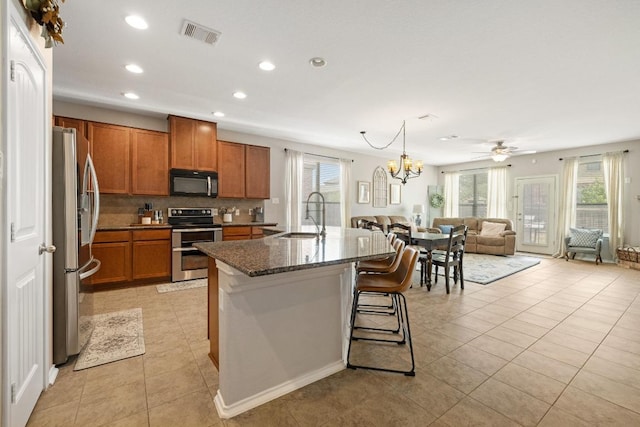 901 Water Hyacinth Loop, Leander, TX 78641 - kitchen featuring stainless steel appliances, brown cabinets, plenty of natural light, open floor plan, and recessed lighting