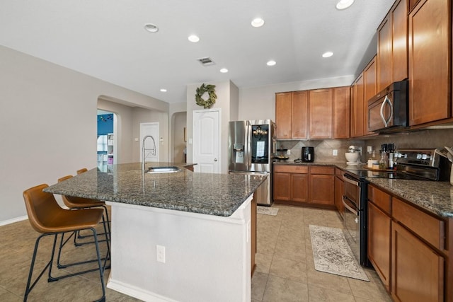 901 Water Hyacinth Loop, Leander, TX 78641 - kitchen featuring appliances with stainless steel finishes, arched walkways, light tile patterned floors, an island with sink, and recessed lighting