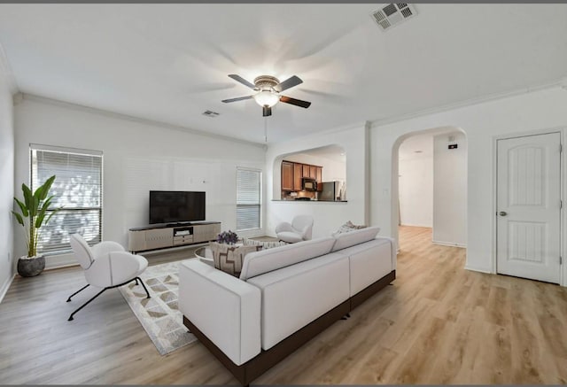 2408 Amur Dr, Austin, TX 78745 - living area with a ceiling fan, light wood-style floors, arched walkways, and ornamental molding