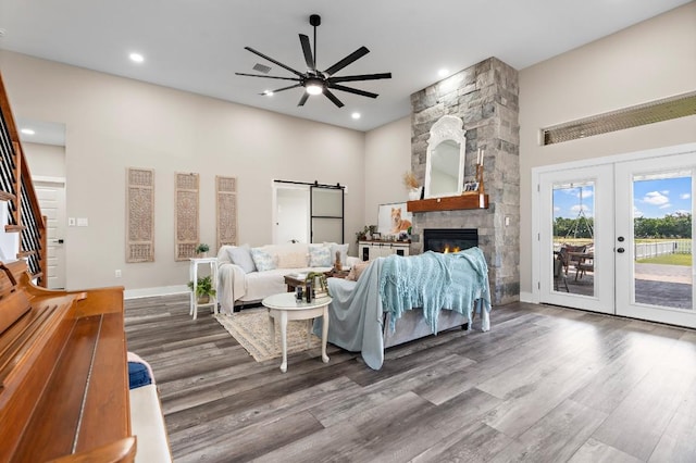 633 N Stovall Dr, Robinson, TX 76706 - living room featuring wood finished floors, a ceiling fan, french doors, a barn door, and stairs