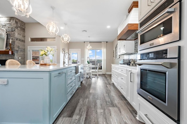 633 N Stovall Dr, Robinson, TX 76706 - kitchen with stainless steel oven, a chandelier, dark wood-type flooring, light countertops, and recessed lighting