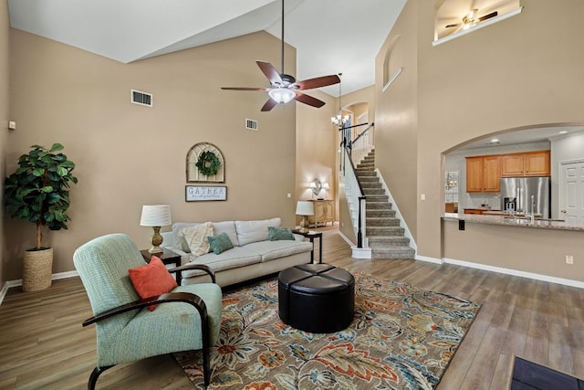 2604 Zambia Dr, Cedar Park, TX 78613 - living room with a ceiling fan, high vaulted ceiling, stairs, wood finished floors, and arched walkways