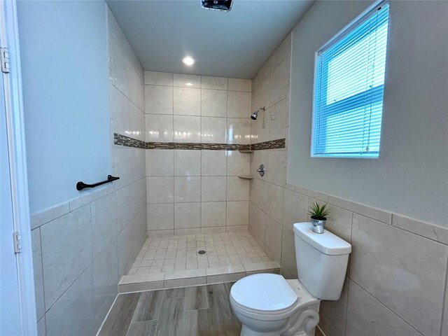 3805 E US-290 Hwy E, Paige, TX 78659 - full bath with tiled shower, tile walls, wood finished floors, and a wainscoted wall