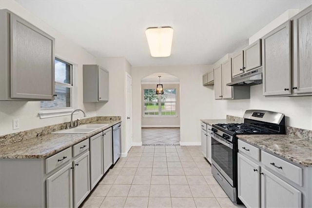 1804 Fairweather Way, Cedar Park, TX 78613 - kitchen with appliances with stainless steel finishes, under cabinet range hood, gray cabinetry, arched walkways, and light tile patterned flooring