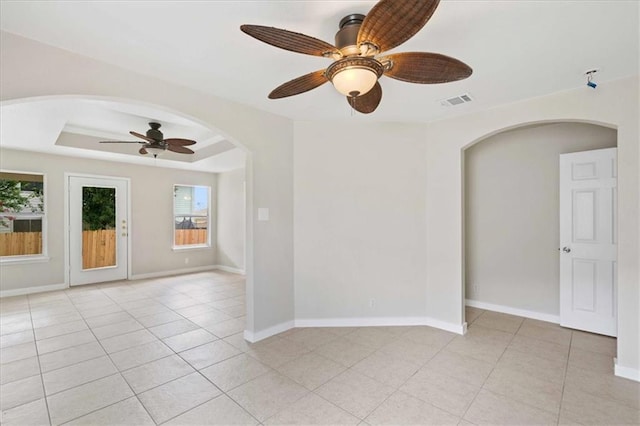 1804 Fairweather Way, Cedar Park, TX 78613 - empty room featuring ceiling fan, arched walkways, light tile patterned flooring, and a raised ceiling