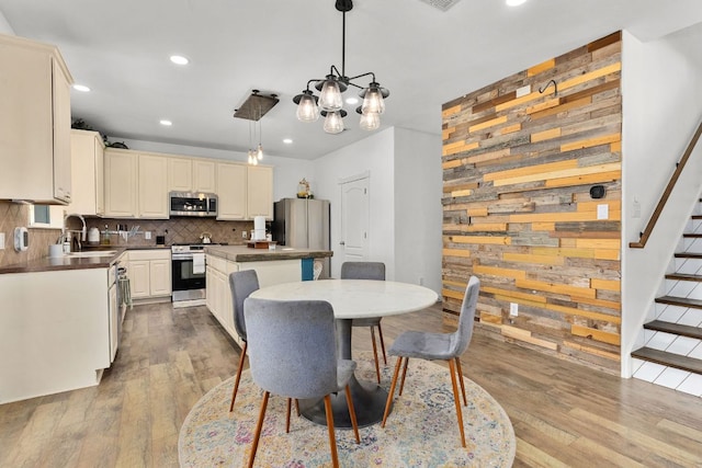 504 Hidden Brook Ln, Round Rock, TX 78665 - dining space with wooden walls, recessed lighting, wood finished floors, a chandelier, and stairway