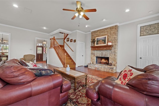 1295 Berry L Ln, Georgetown, TX 78626 - living area with wood finished floors, stairway, a stone fireplace, a ceiling fan, and plenty of natural light
