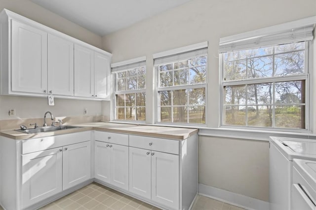 1295 Berry L Ln, Georgetown, TX 78626 - laundry room featuring cabinet space, washing machine and clothes dryer, and light tile patterned flooring
