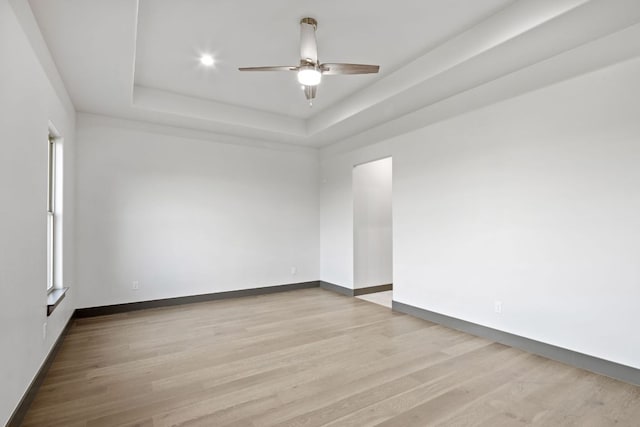 311 Out Crop, Horseshoe Bay, TX 78657 - unfurnished room featuring ceiling fan, a tray ceiling, and light wood-style floors