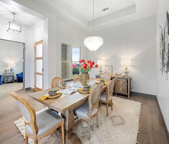 311 Out Crop, Horseshoe Bay, TX 78657 - dining area featuring a chandelier, light wood-style floors, and a raised ceiling