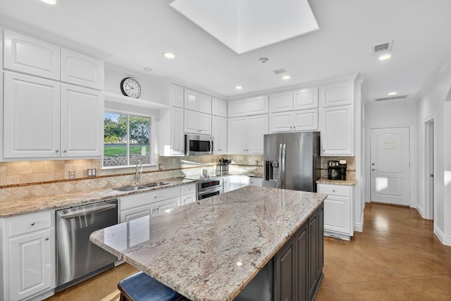 3000 Driftwood Ln, Horseshoe Bay, TX 78657 - kitchen with appliances with stainless steel finishes, white cabinetry, decorative backsplash, a center island, and recessed lighting