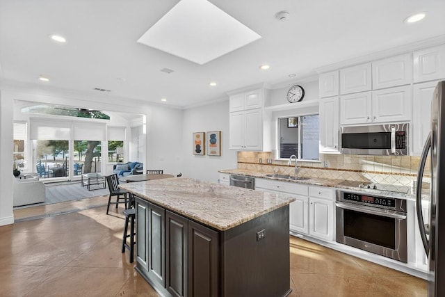 3000 Driftwood Ln, Horseshoe Bay, TX 78657 - kitchen with stainless steel appliances, white cabinetry, recessed lighting, tasteful backsplash, and ornamental molding