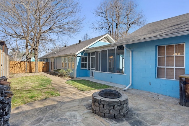 4419 Sinclair Ave, Austin, TX 78756 - back of property with a fire pit, roof with shingles, a patio area, concrete block siding, and a sunroom