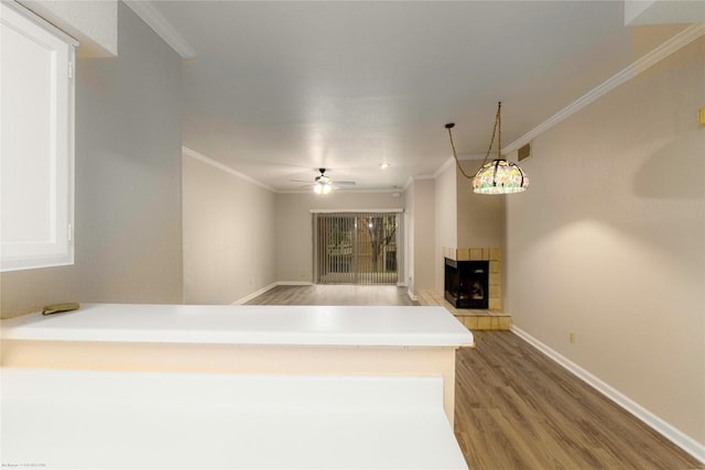 2450 Wickersham Ln Unit 1001, Austin, TX 78741 - unfurnished living room with light wood-style floors, ornamental molding, a fireplace, and a ceiling fan
