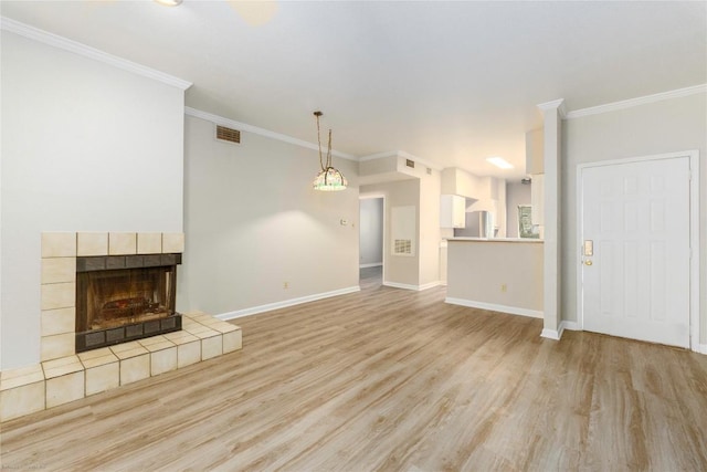2450 Wickersham Ln Unit 1001, Austin, TX 78741 - unfurnished living room featuring light wood-style floors, ornamental molding, and a fireplace