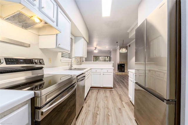 2450 Wickersham Ln Unit 1001, Austin, TX 78741 - kitchen with stainless steel appliances, custom range hood, light wood-type flooring, white cabinets, and a peninsula