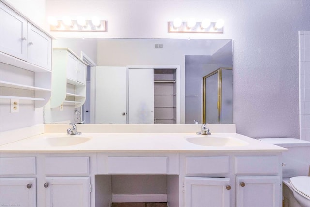 2450 Wickersham Ln Unit 1001, Austin, TX 78741 - full bath with double vanity, a shower stall, a closet, and a textured wall