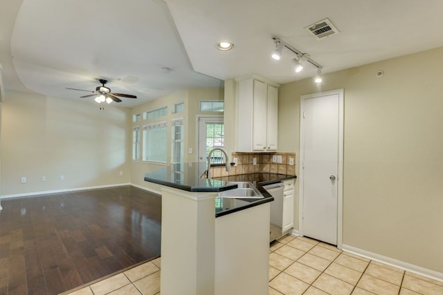 9525 N Capital Of Texas Hwy Unit 414, Austin, TX 78759 - kitchen with stainless steel dishwasher, dark countertops, a peninsula, white cabinets, and ceiling fan
