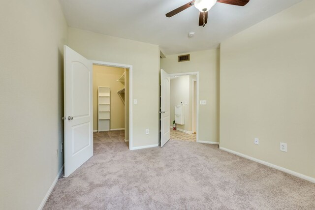 9525 N Capital Of Texas Hwy Unit 414, Austin, TX 78759 - unfurnished bedroom with a walk in closet, light colored carpet, a ceiling fan, and a closet