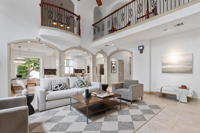 7608 Journeyville Dr, Austin, TX 78735 - living room with arched walkways, ornate columns, a high ceiling, and light tile patterned floors
