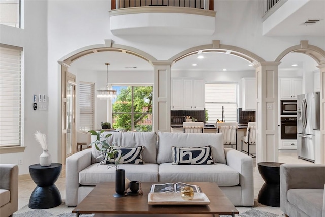 7608 Journeyville Dr, Austin, TX 78735 - living room with a towering ceiling, arched walkways, a chandelier, recessed lighting, and decorative columns