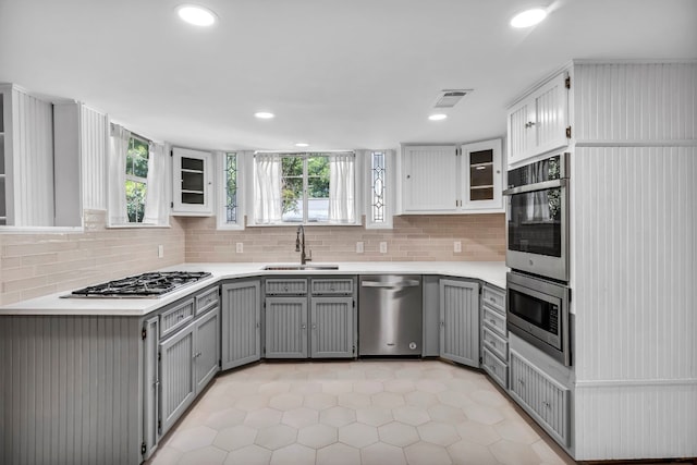 1806 S Main St, Georgetown, TX 78626 - kitchen featuring stainless steel appliances, gray cabinets, light tile patterned floors, decorative backsplash, and recessed lighting