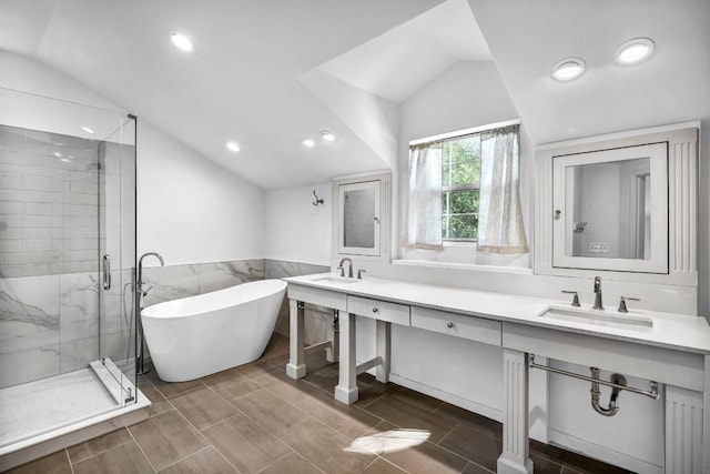 1806 S Main St, Georgetown, TX 78626 - bathroom featuring lofted ceiling, double vanity, a stall shower, a freestanding bath, and recessed lighting