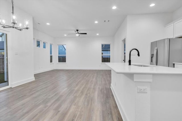 8609 San Giano Cv, Round Rock, TX 78665 - unfurnished living room featuring recessed lighting, light wood-style floors, a chandelier, and a ceiling fan
