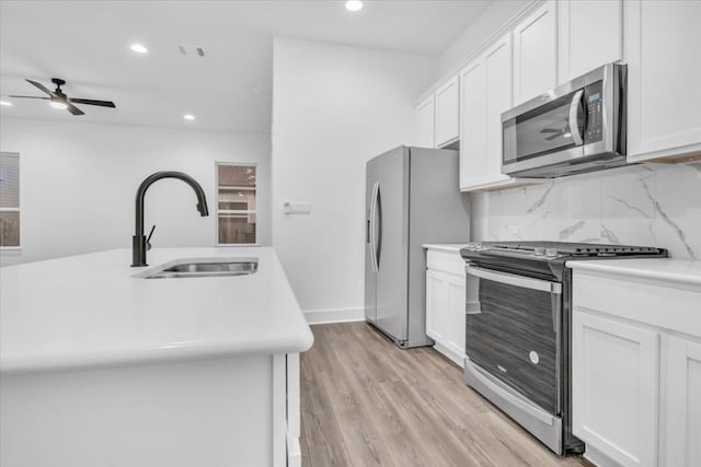 8609 San Giano Cv, Round Rock, TX 78665 - kitchen with appliances with stainless steel finishes, light countertops, ceiling fan, recessed lighting, and white cabinetry
